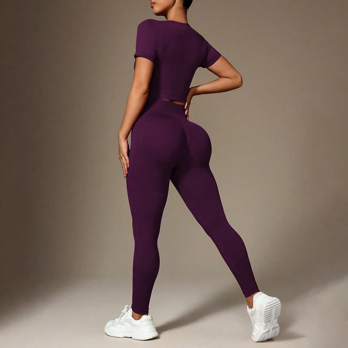 Conjunto deportivo de mujer compuesto por top de manga corta con cuello redondo de color liso y pantalones largos elásticos sin costuras para hacer